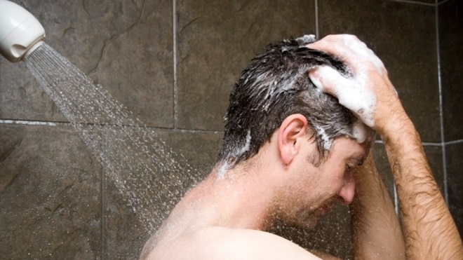 Je haar wassen met shampoo onder de douche